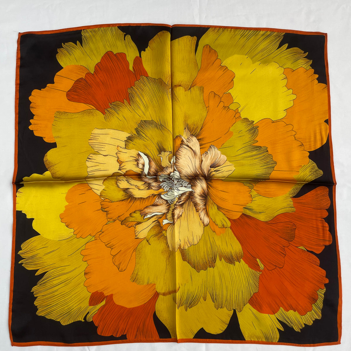 The Golden Flowers scarf laid flat, with a large yellow and orange flower on a dark background