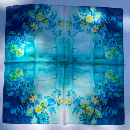 The Blue Rose scarf laid flat, with a pale turquoise centre framed by flowers and blue foliage