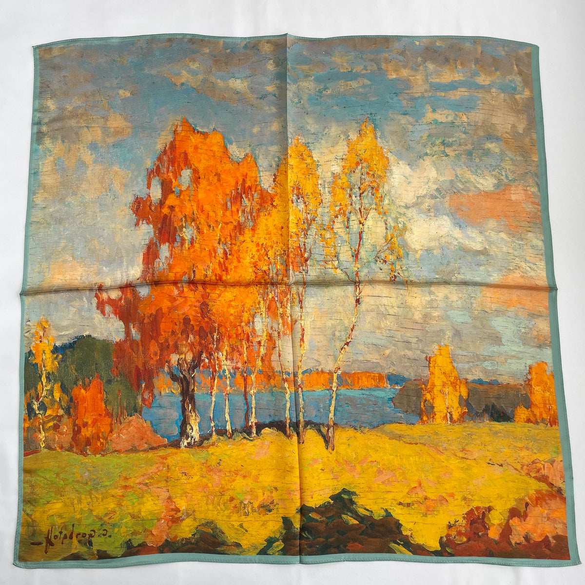 The Autumn Painting scarf laid flat, with orange and yellow trees in a blue landscape